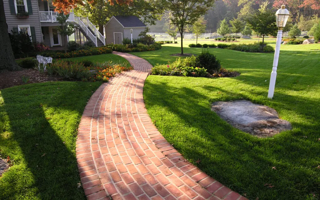 Brick Path Through Green Grass And Garden Beds