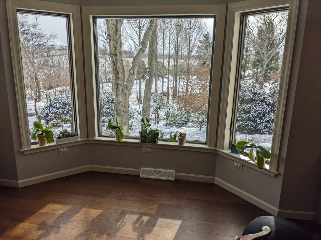 A Wide Window View Of A Snowy Inside Out Garden Designed By Hanselman Gardens.