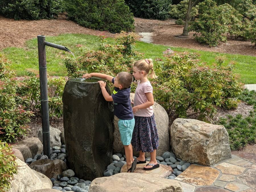 Children Playing At A Tsukubai Water Fountain Design And Installed By Hanselman Landscape And Gardens In Lancaster, Pa.